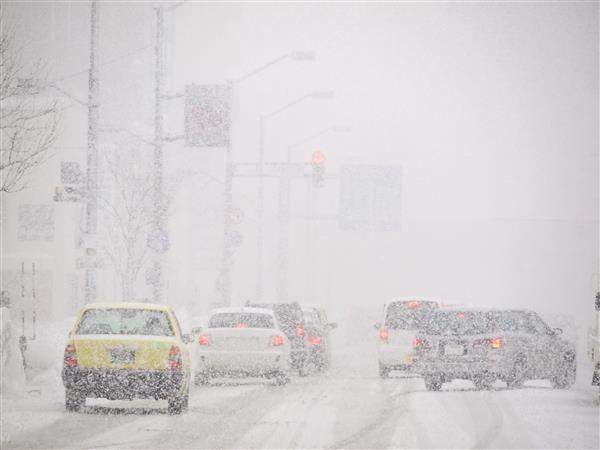 Cars driving on snow-covered roads in the winter Cars driving on snow-covered roads in the winter